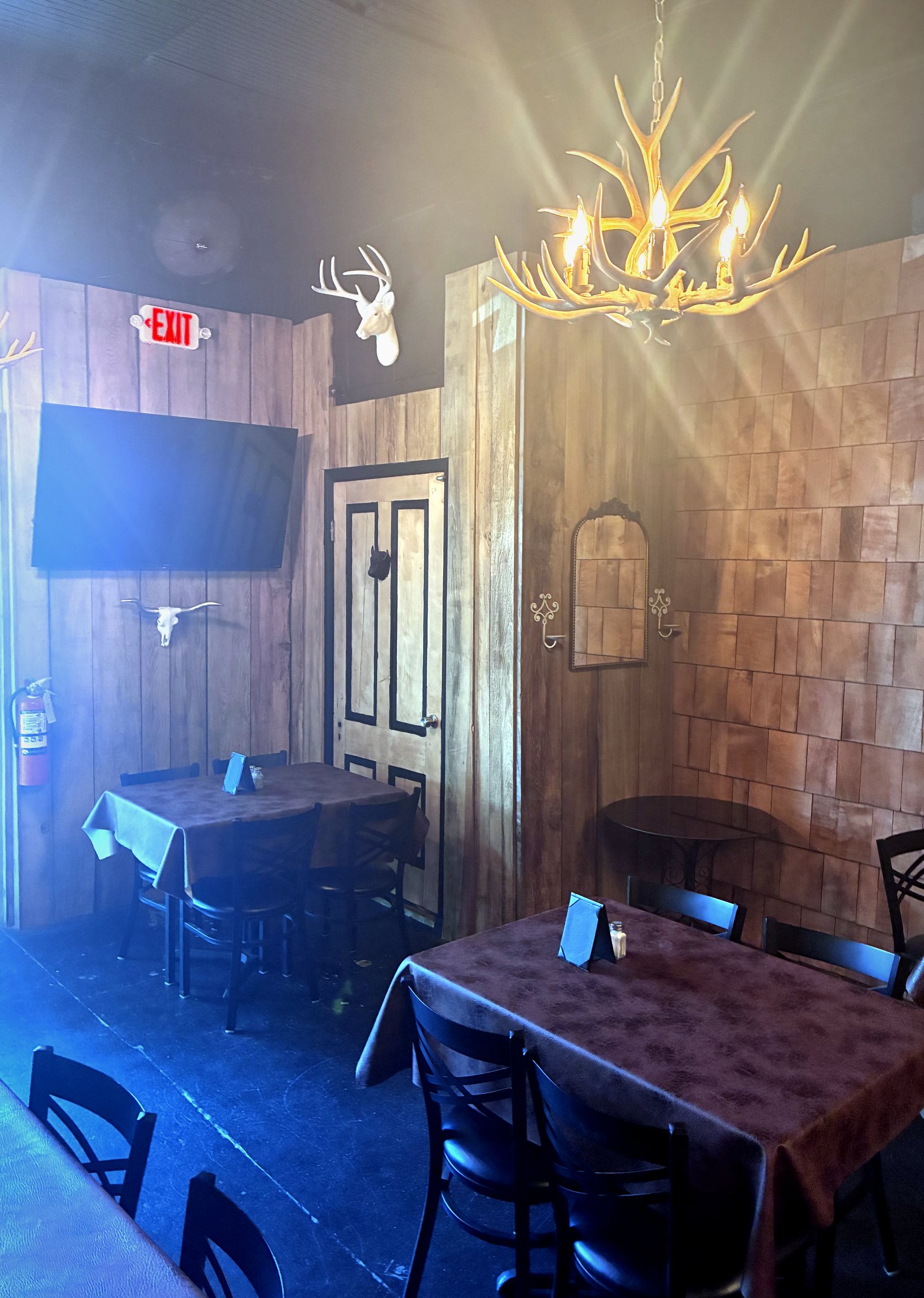 The lounge at 329 — antler chandelier, warm wood