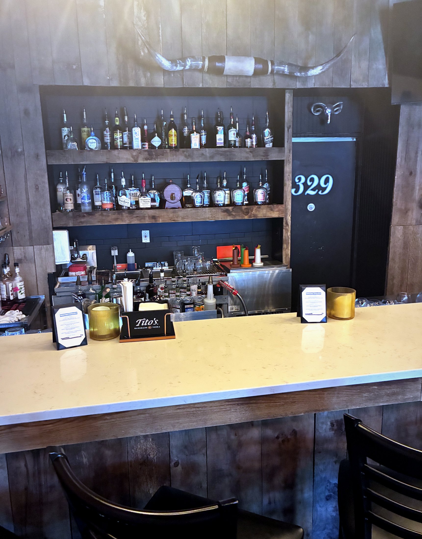 The 329 back bar — bottles, the longhorn, the 329 door